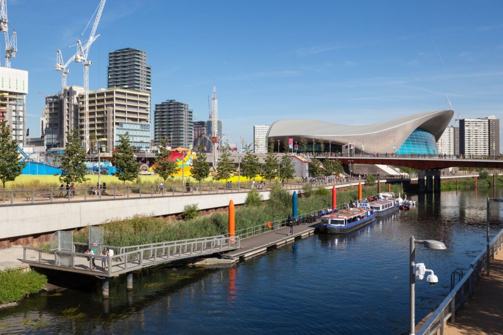 Budova London Aquatics Centre (vpravo) bola postavená počas príprav na Letné olympijské hry v roku 2012. Dnes slúži verejnosti. Zdroj: Shutterstock